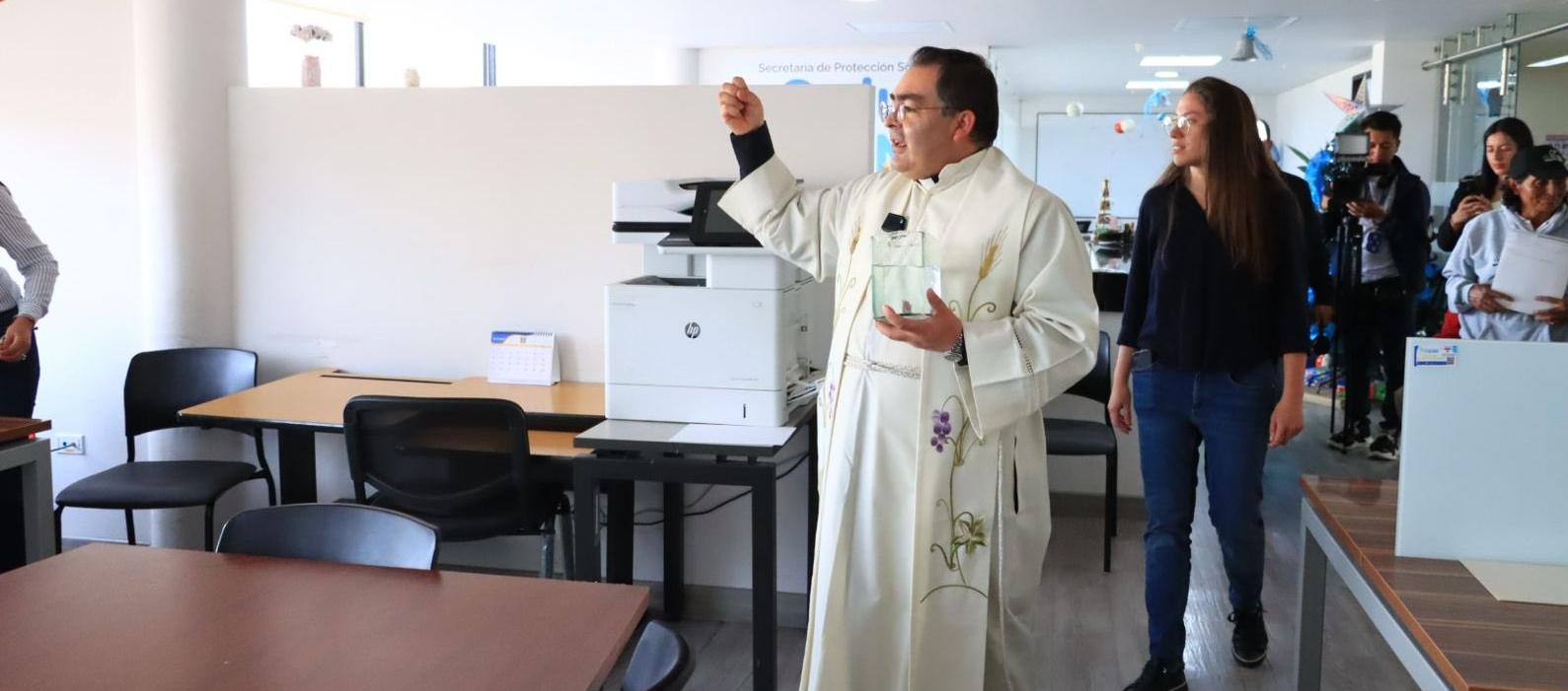 Un sacerdote rocía agua bendita en el despacho del nuevo alcalde de Tunja