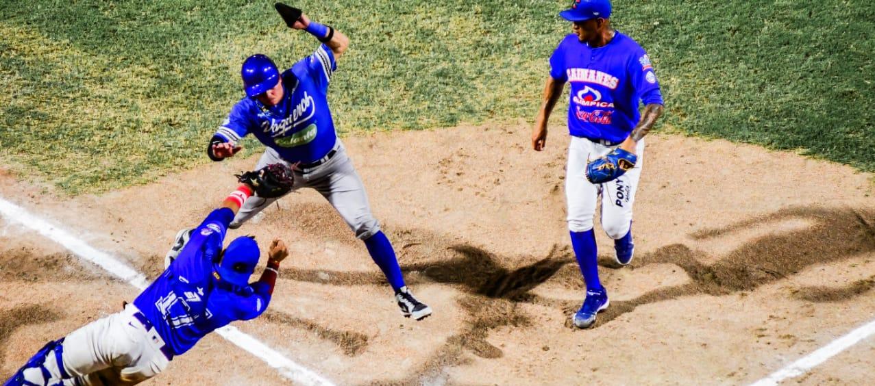 Bryan Flete evita ser tocado por el receptor de Caimanes, Jair Camargo, y anota la tercera carrera de Vaqueros.