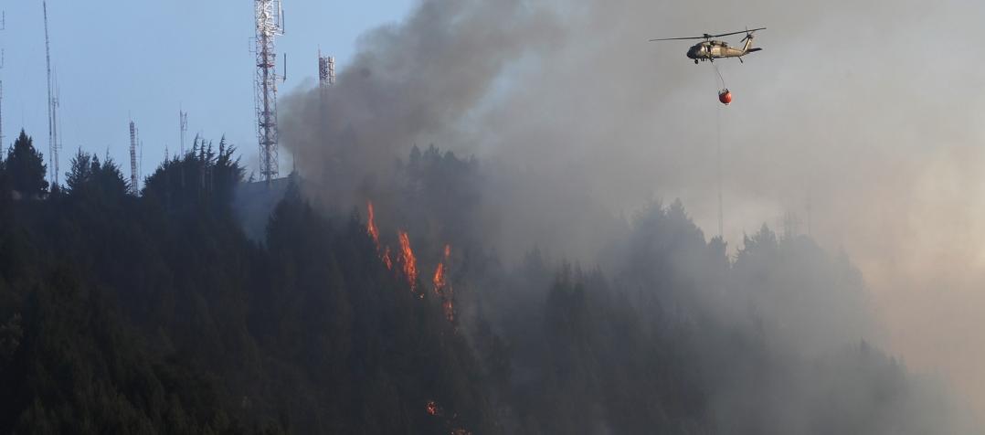 Un helicóptero combate un incendio forestal en el cerro El Cable, en Bogotá.