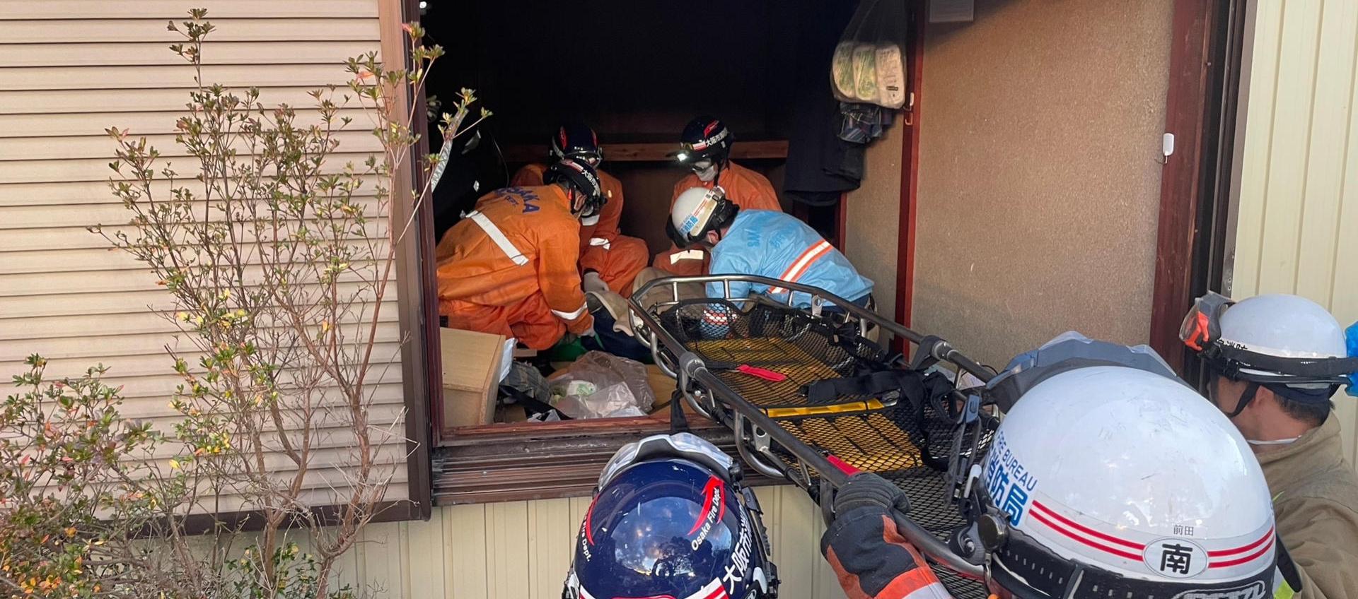 Rescatistas sacan a la anciana de la vivienda.