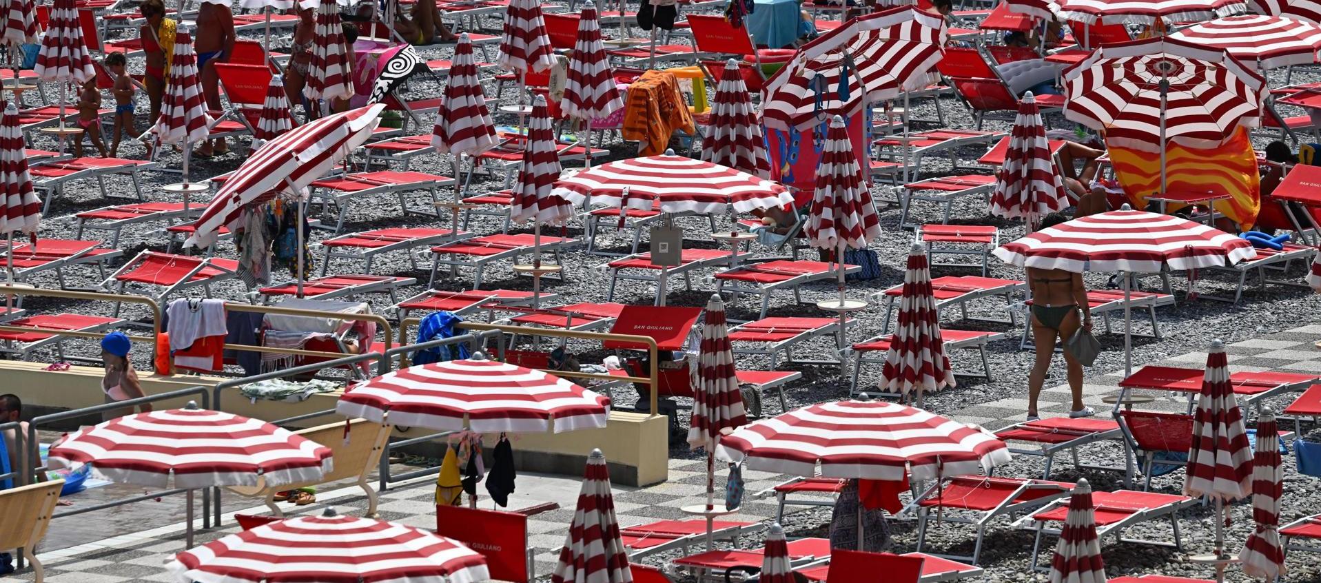 Bañistas buscan refugio del sol en una playa de Génova, Italia, el 20 de julio de 2023
