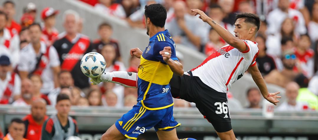 Pablo Solari, de River Plate, disputa el balón con Jorge Figal, de Boca.