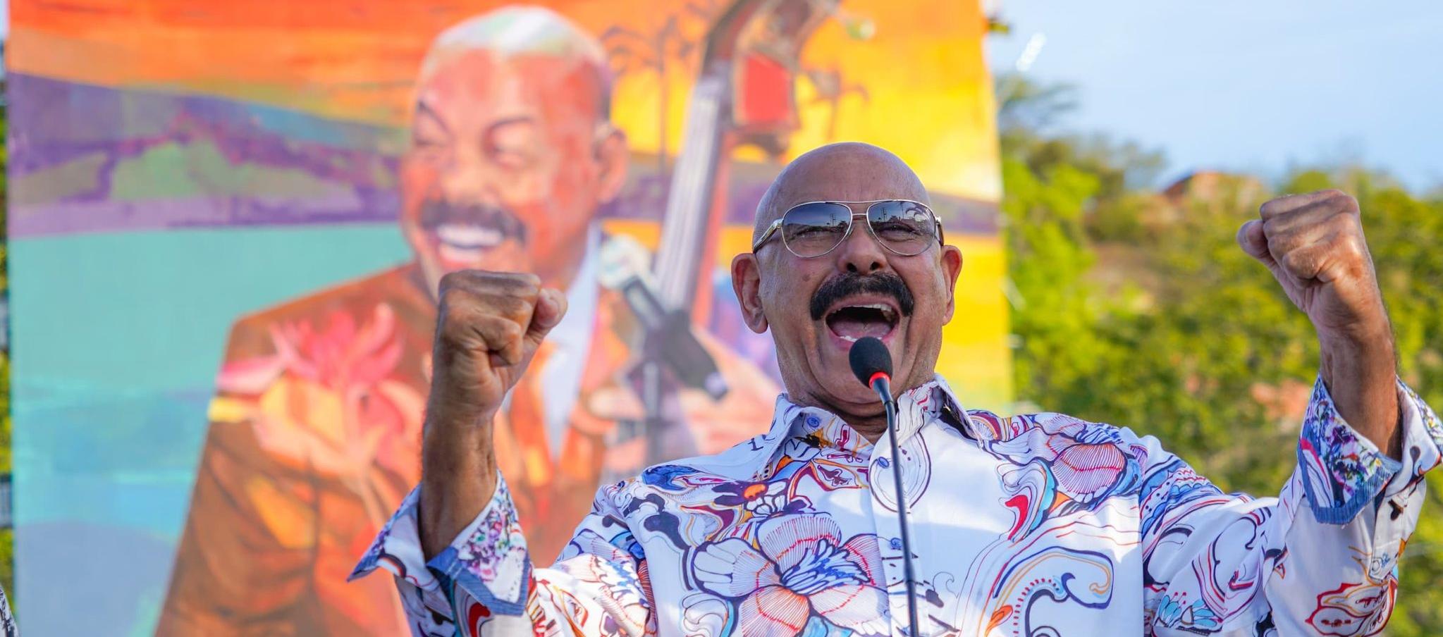 Óscar D' León y al fondo el gigantesco mural develado en su honor. 