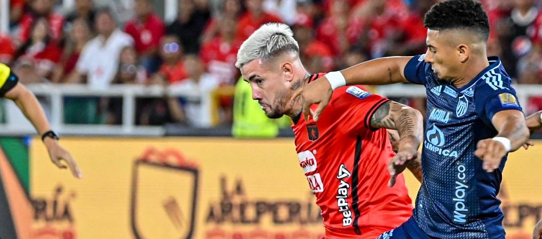 Rodrigo Holgado, autor del primer gol del América, disputa la pelota con Edwin Herrera. 