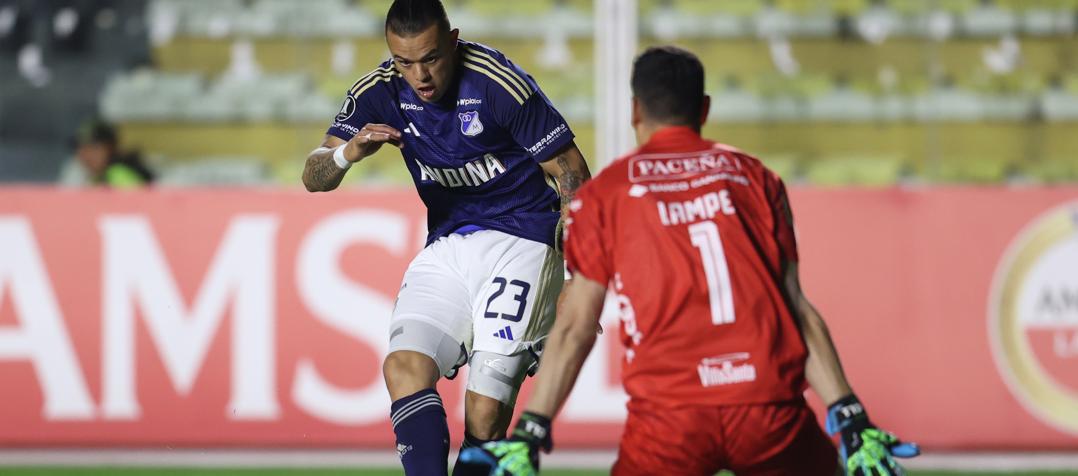 Leonardo Castro, autor de los dos goles de Millonarios, en un mano a mano con el portero Carlos Lampe.