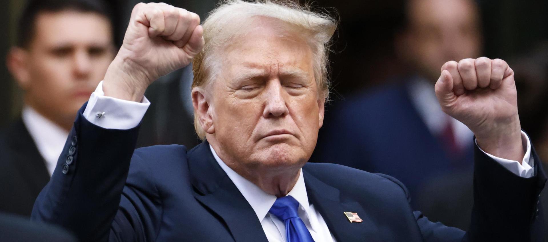 Donald Trump hace gestos a los medios de comunicación y a la multitud afuera de la Torre Trump. 