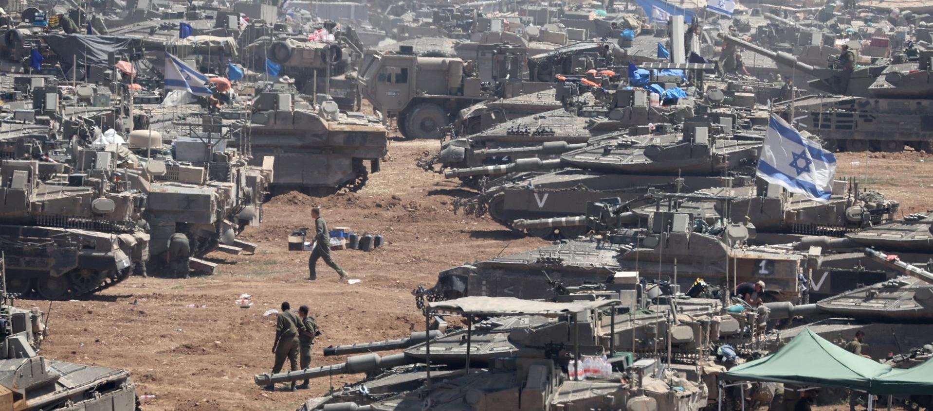 Soldados israelíes junto a sus vehículos militares se reúnen en Gaza.