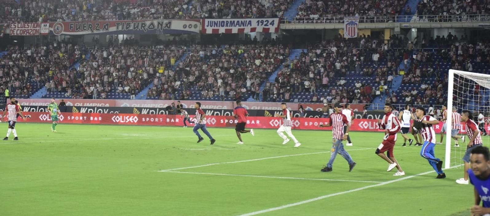 Hinchas invadieron la cancha tras los enfrentamientos en la tribuna sur. 