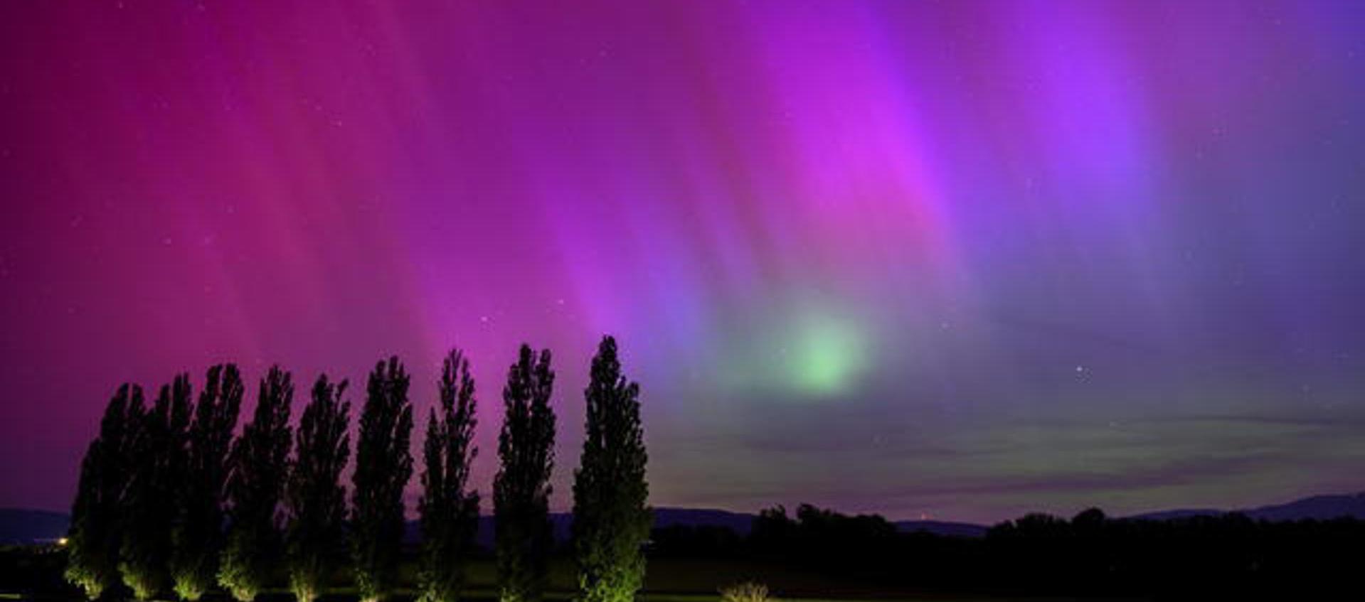 Vista de la aurora boreal vista durante la noche del viernes en Daillens, Suiza.