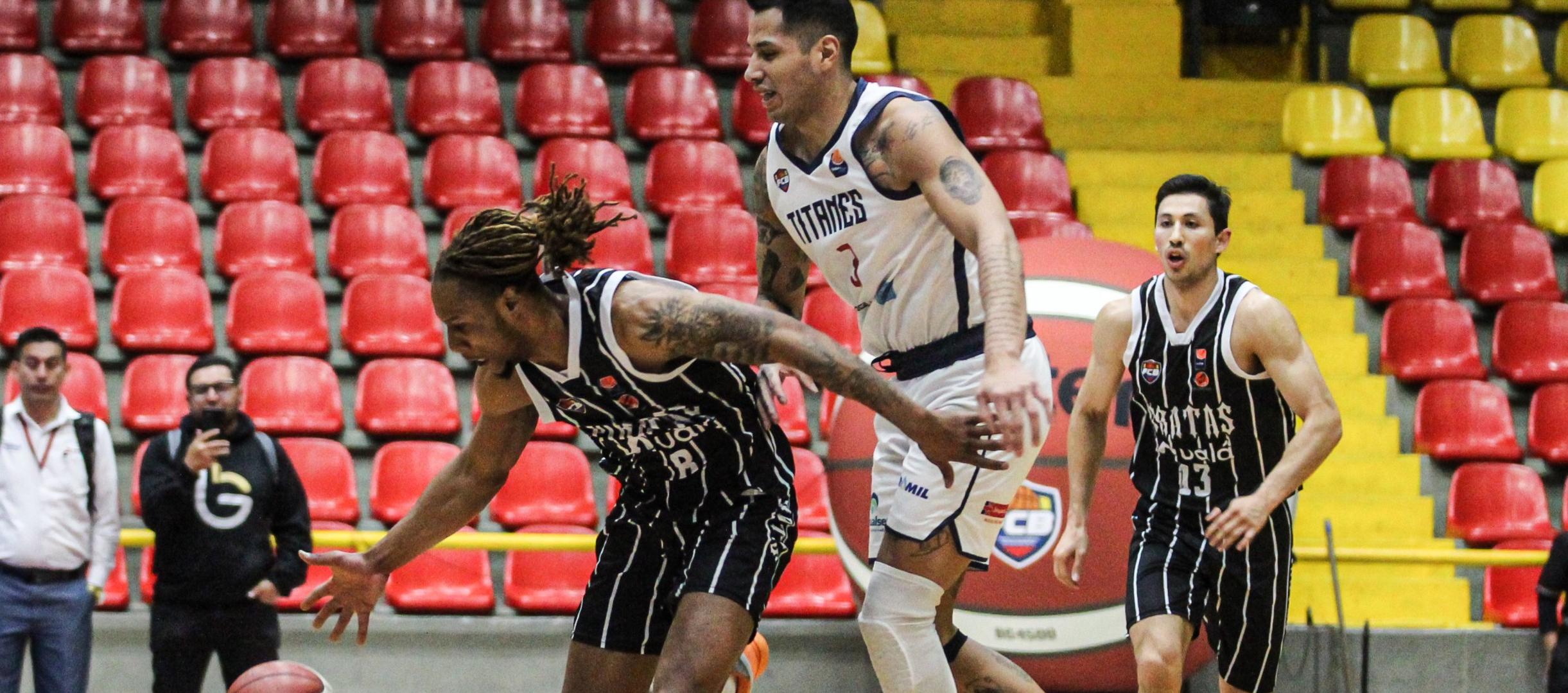 Fabián Jaimes, de Titanes, intenta impedir el avance de Tyrone Perry, de Piratas. 