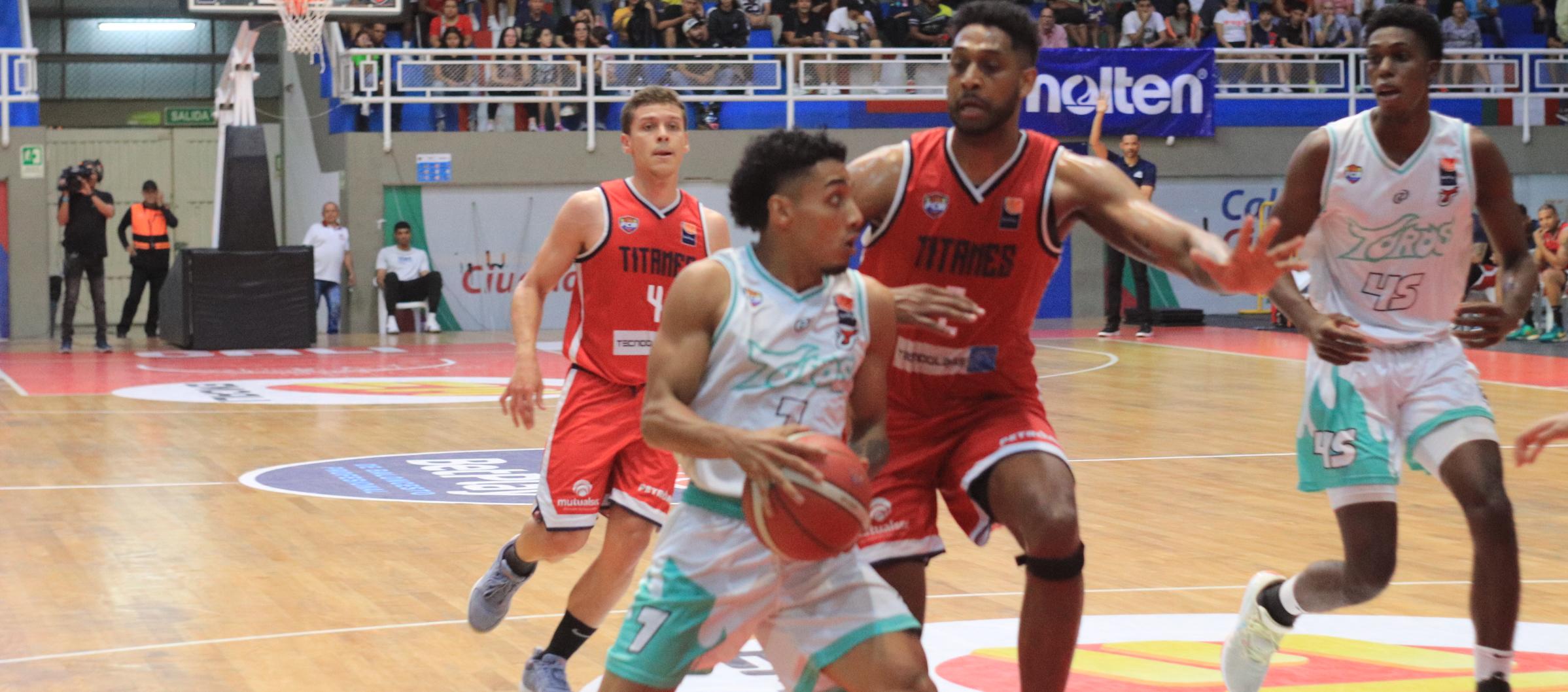 Tonny Trocha$3 Titanes, intenta impedir el avance de Samuel Mojica, de Toros del Valle.