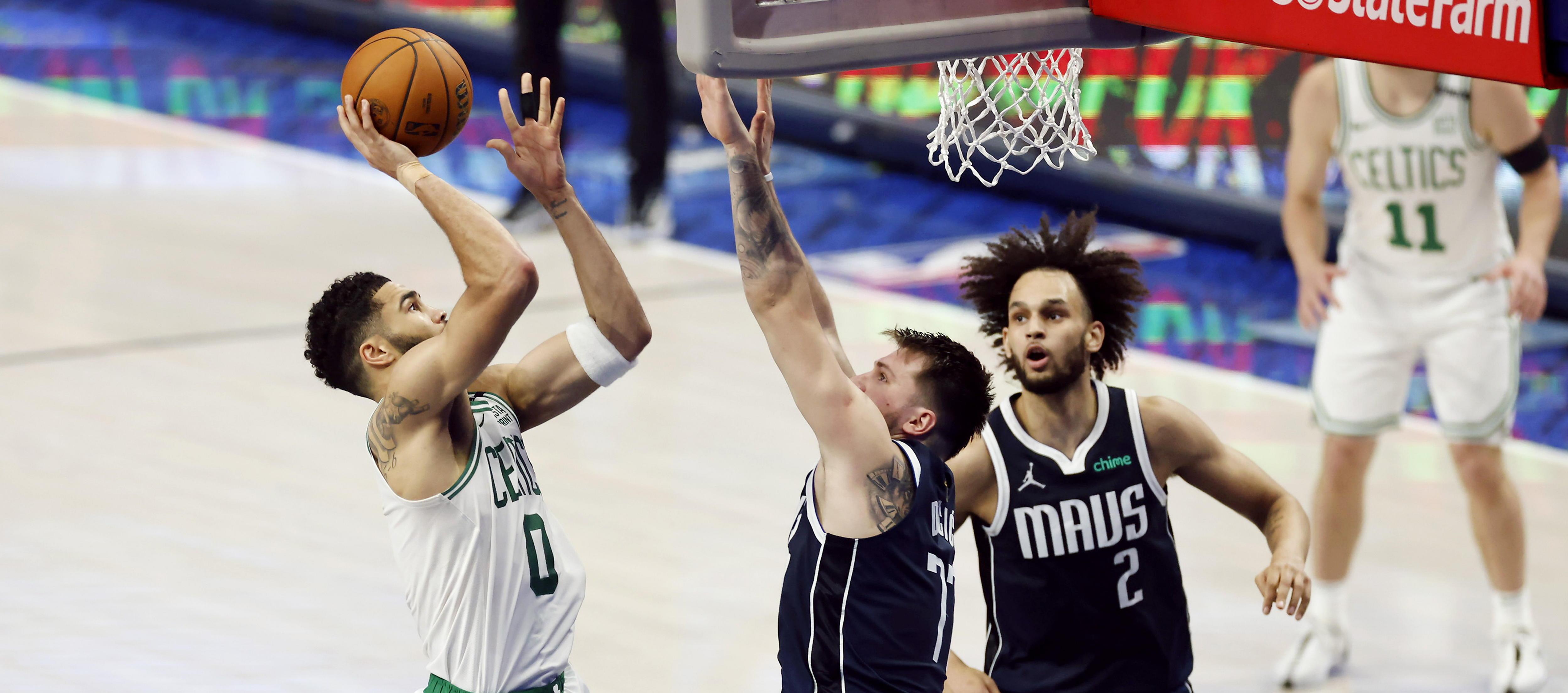 Luka Doncic intenta bloquear el lanzamiento de Jayson Tatum. 