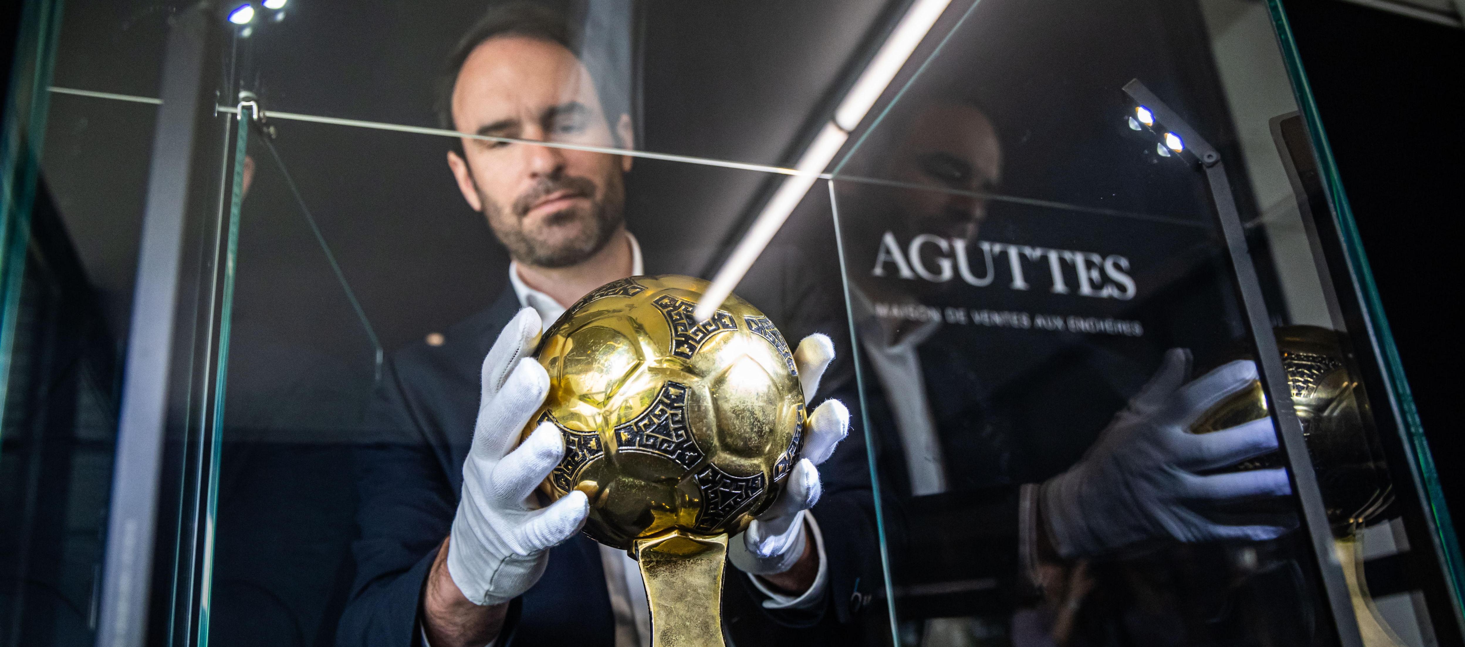 Francois Thierry, de la casa de subastas Aguttes, con el Balón de Oro de Maradona. 