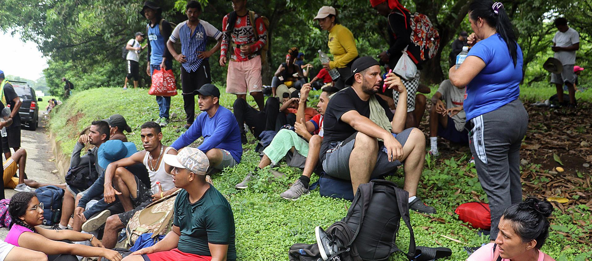 Migrantes descansan a un costado de la vía, en el municipio de Huixtla en Chiapas (México).