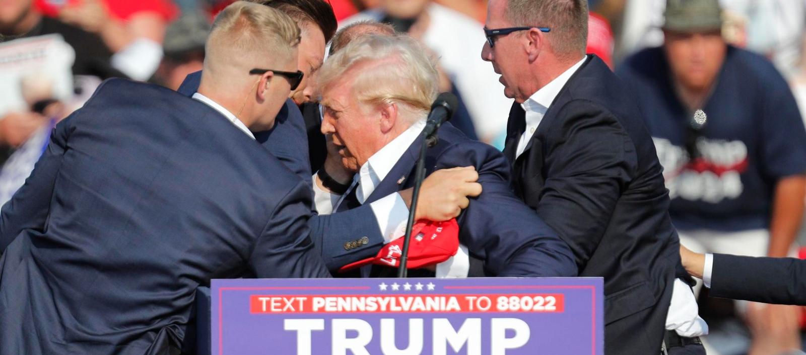 Momento en que Donald Trump es retirado por sus escoltas. 