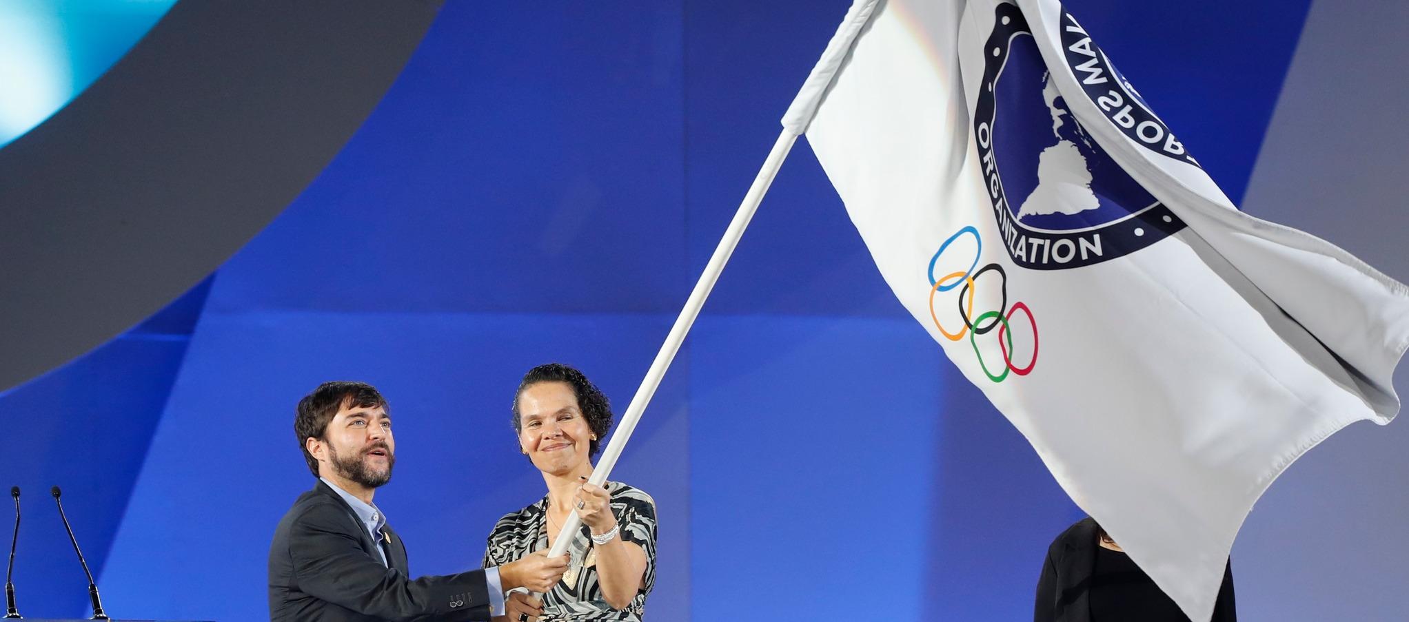 El exalcalde Jaime Pumarejo y la exministra del Deporte, Astrid Rodríguez con la bandera de los Panamericanos.