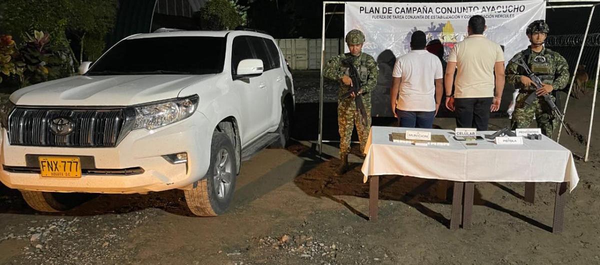 La camioneta y los capturados junto al uniformado.