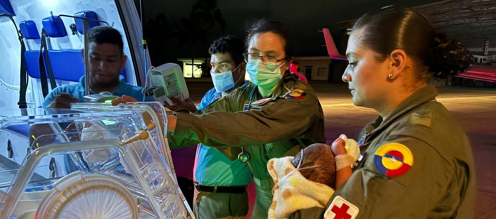 El bebé en manos de personal militar antes de ser ingresado a la aeronave medicalizada.