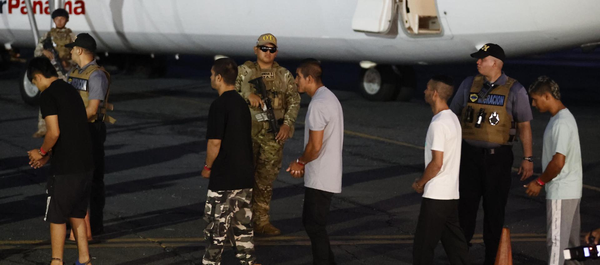 Migrantes esposados antes de ser deportados