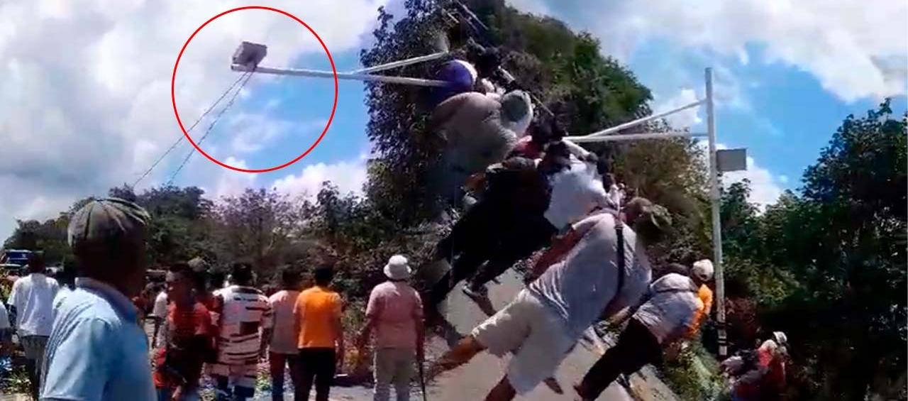 Momento en que los manifestantes tumbaron la cámara de fotomultas. 