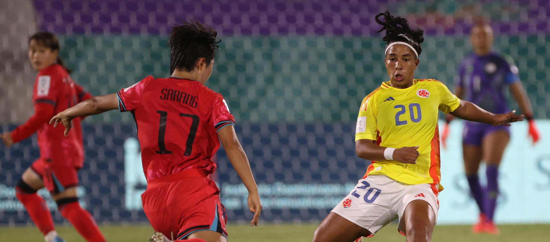 Nam Sarang, de Corea del Sur, disputa el balón con Reina Torres.