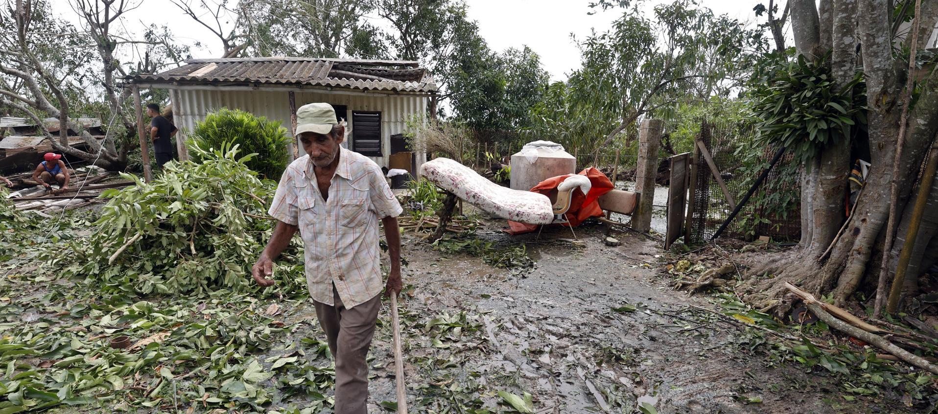 Hombre caminando entre escombros tras el paso del huracán Rafael. 
