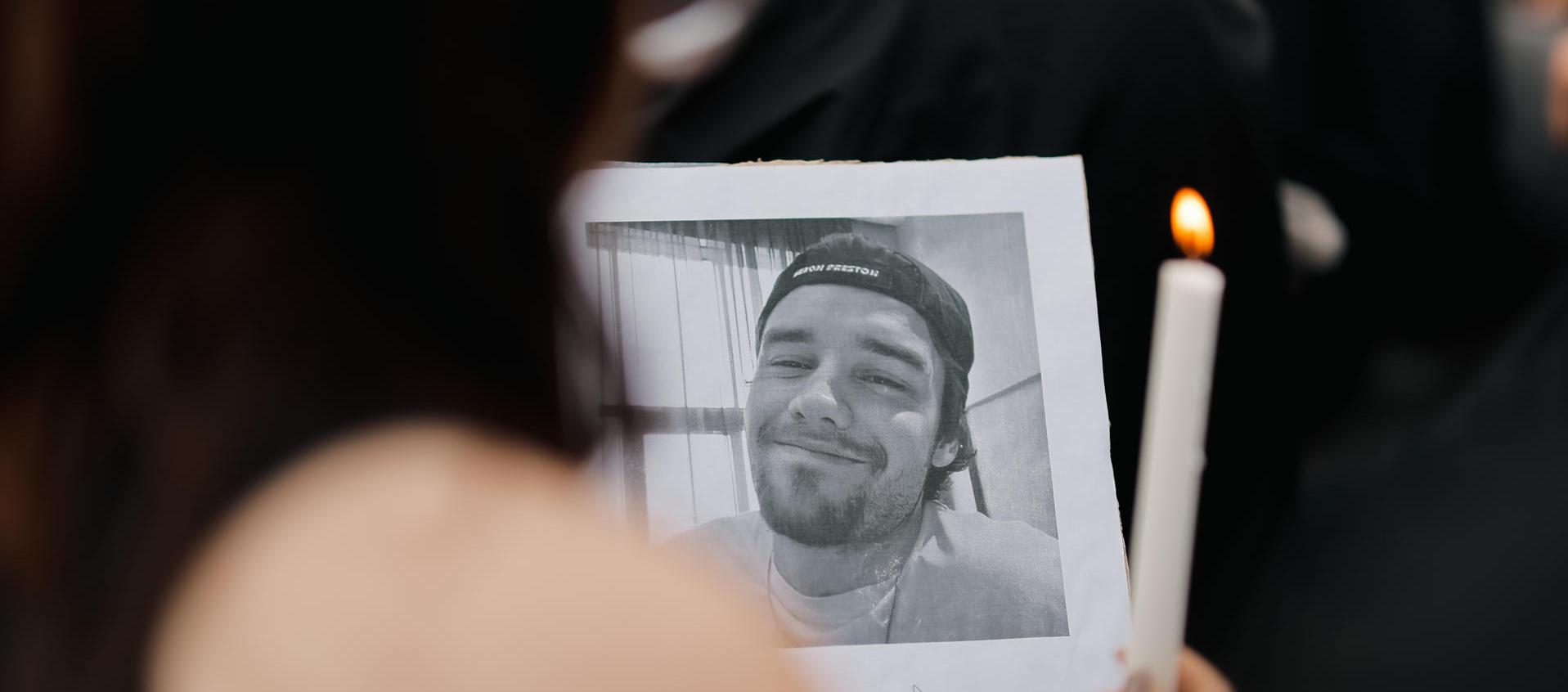 Una fanática sostiene una foto del cantante Liam Payne.