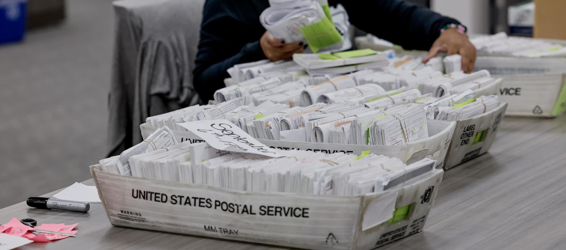 Una trabajadora del Departamento de Registro y Elecciones del Condado de Fulton clasifica los formularios de registro de votantes.