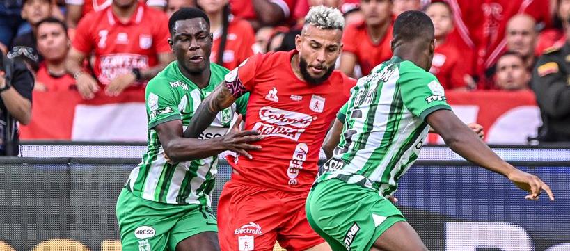 Duván Vergara busca abrirse paso entre dos jugadores de Nacional. 