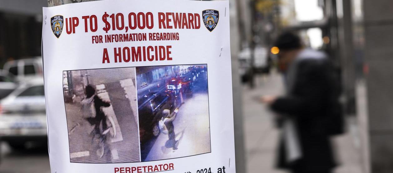 Cartel de "Se busca" en Nueva York cerca del lugar donde asesinaron a Brian Thompson.