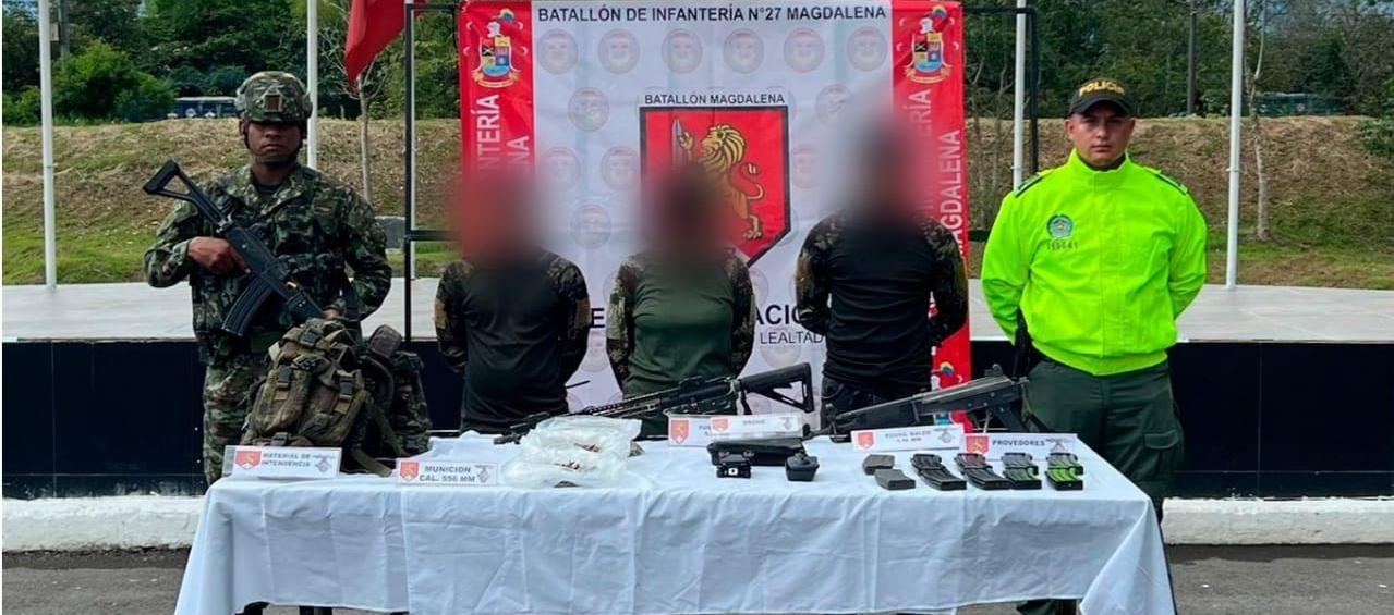 Tres de los capturados con drones y material bélico. 