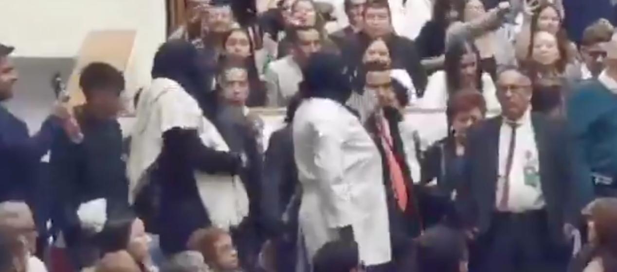 Momentos en que los encapuchados eran sacados del auditorio. 