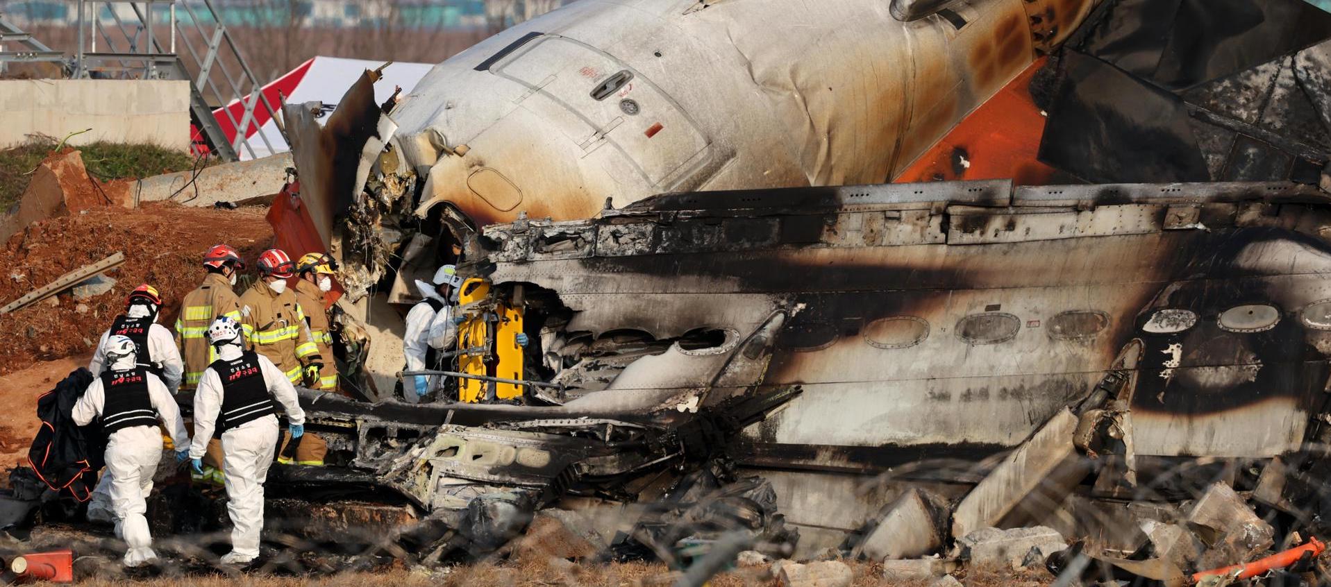 Los bomberos trabajan en los restos del avión Jeju Air en el Aeropuerto Internacional de Muan.
