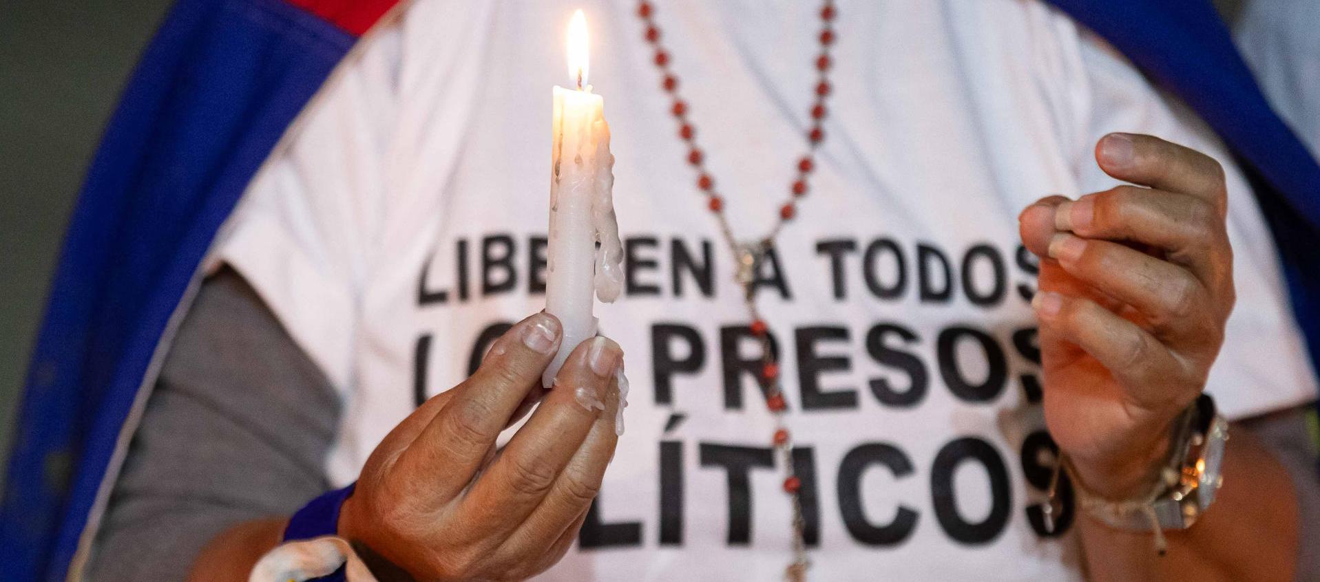 Una mujer sostiene una vela durante una vigilia por los "presos políticos". 