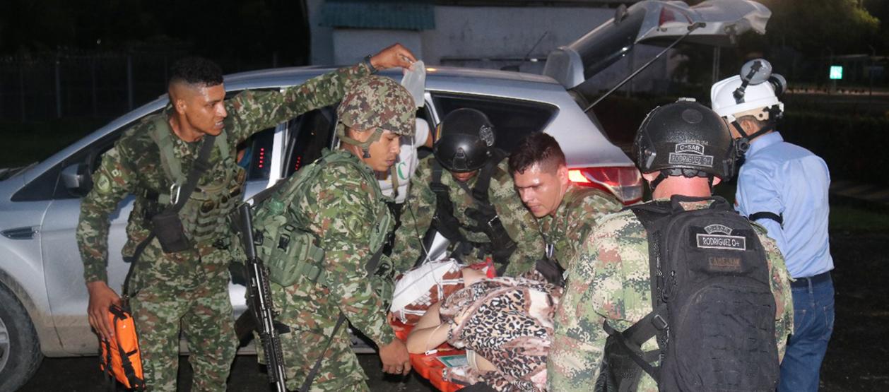 Integrantes de las Fuerzas Militares trasladando a una persona herida este jueves.