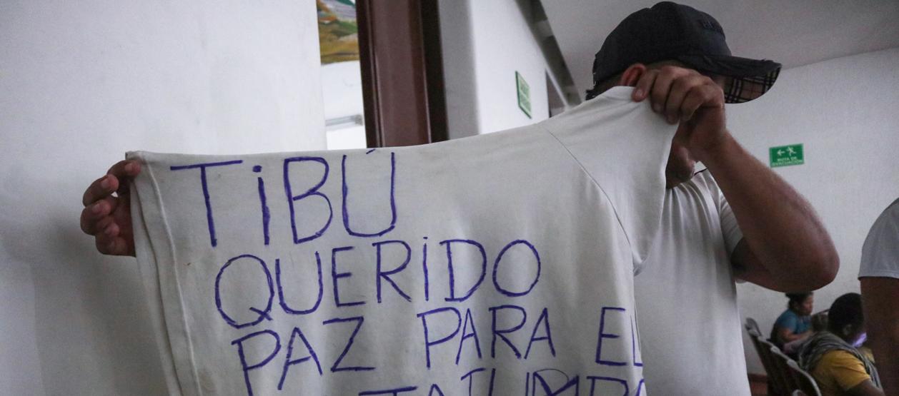 Un hombre desplazado por la violencia muestra una camiseta que pide paz para el Catatumbo.