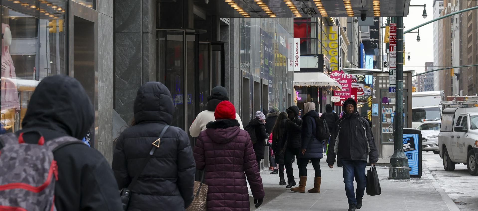 Las personas pasan junto a un refugio para migrantes en el antiguo Hotel Row NYC en Nueva York.