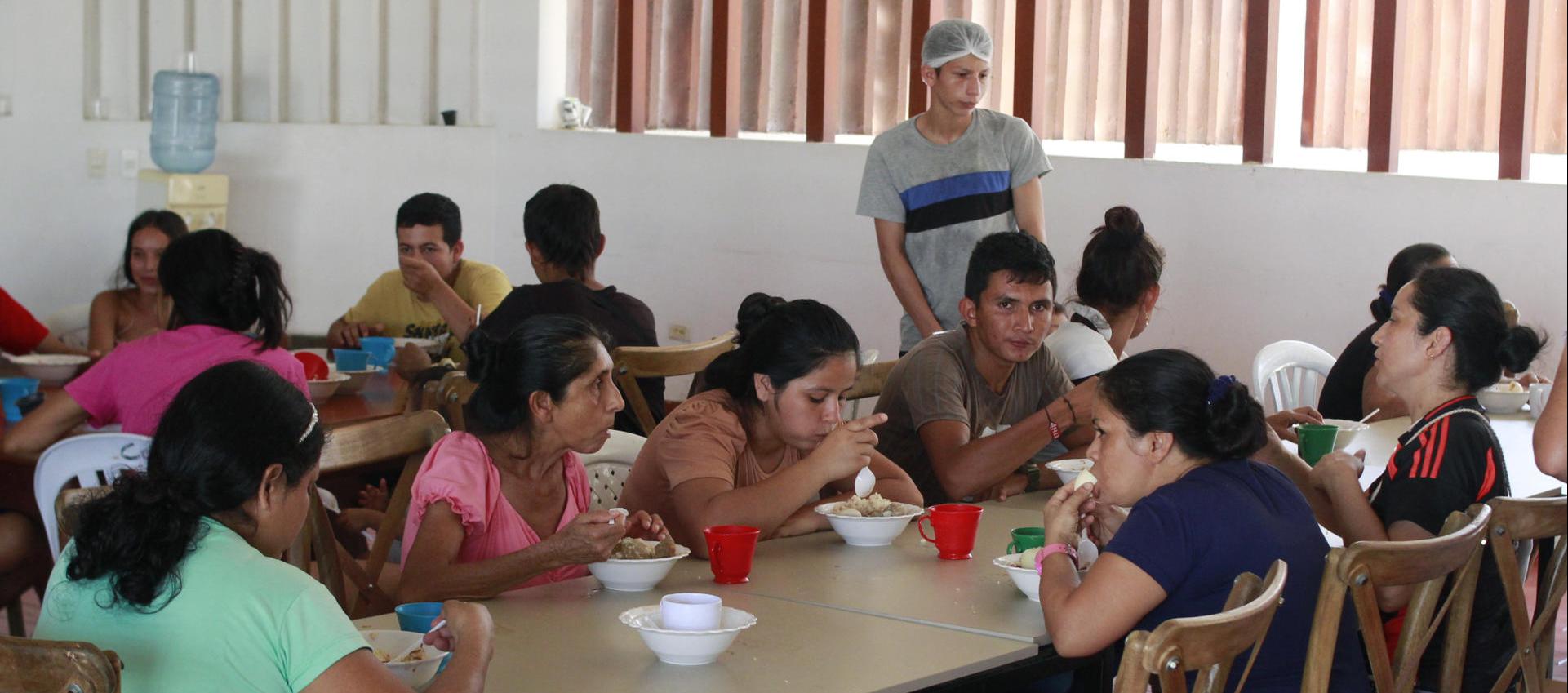Varias personas comen en el Albergue del Seminario Menor en Tibú.