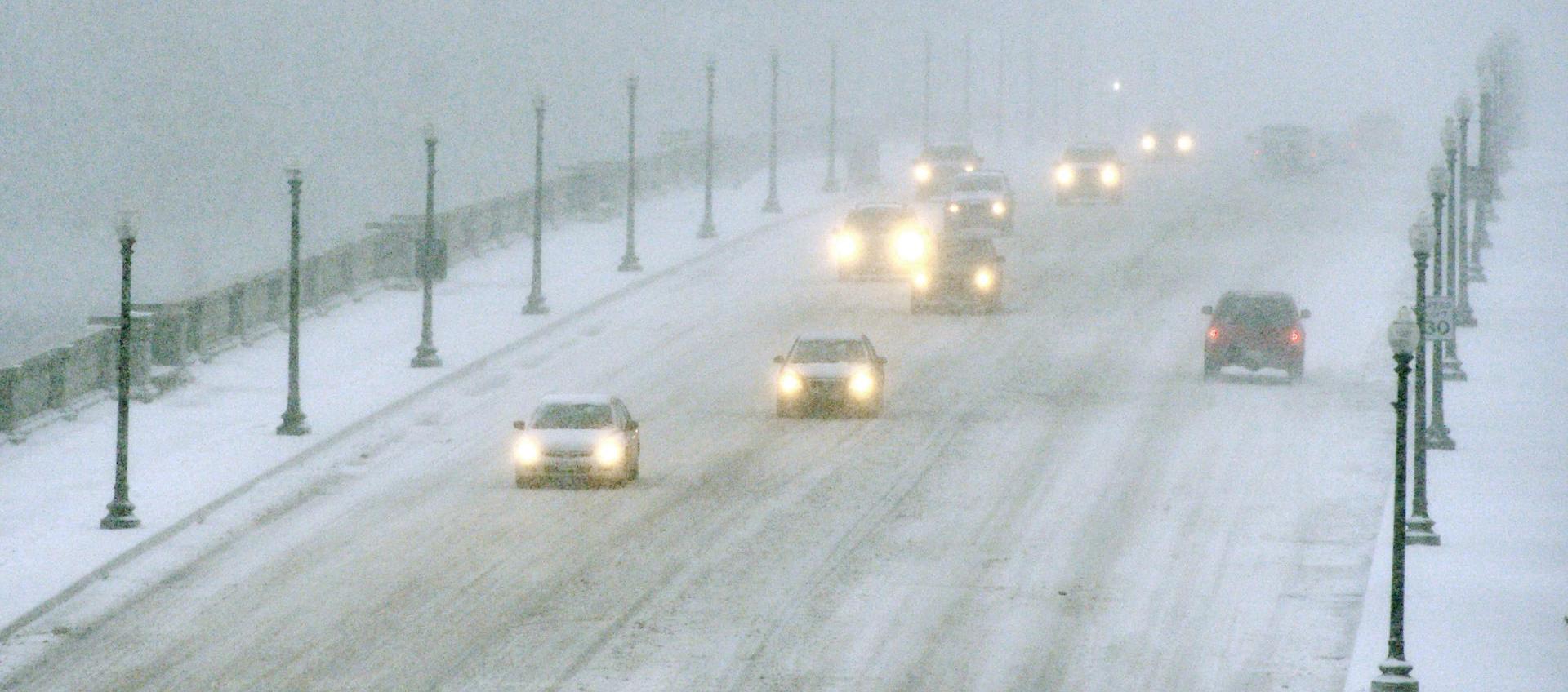 Vehículos avanzando en medio de la nieve en el Puente Memorial de Arlington que conecta a Virginia con Washington.