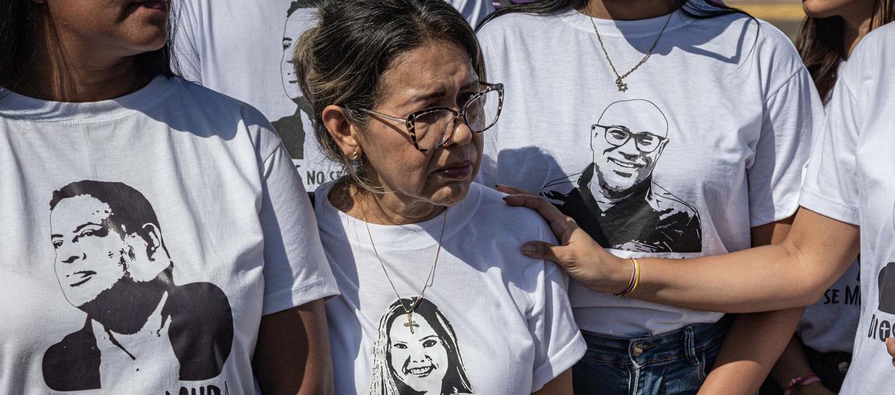 Personas portan camisetas con imágenes de sus familiares detenidos durante una manifestación.