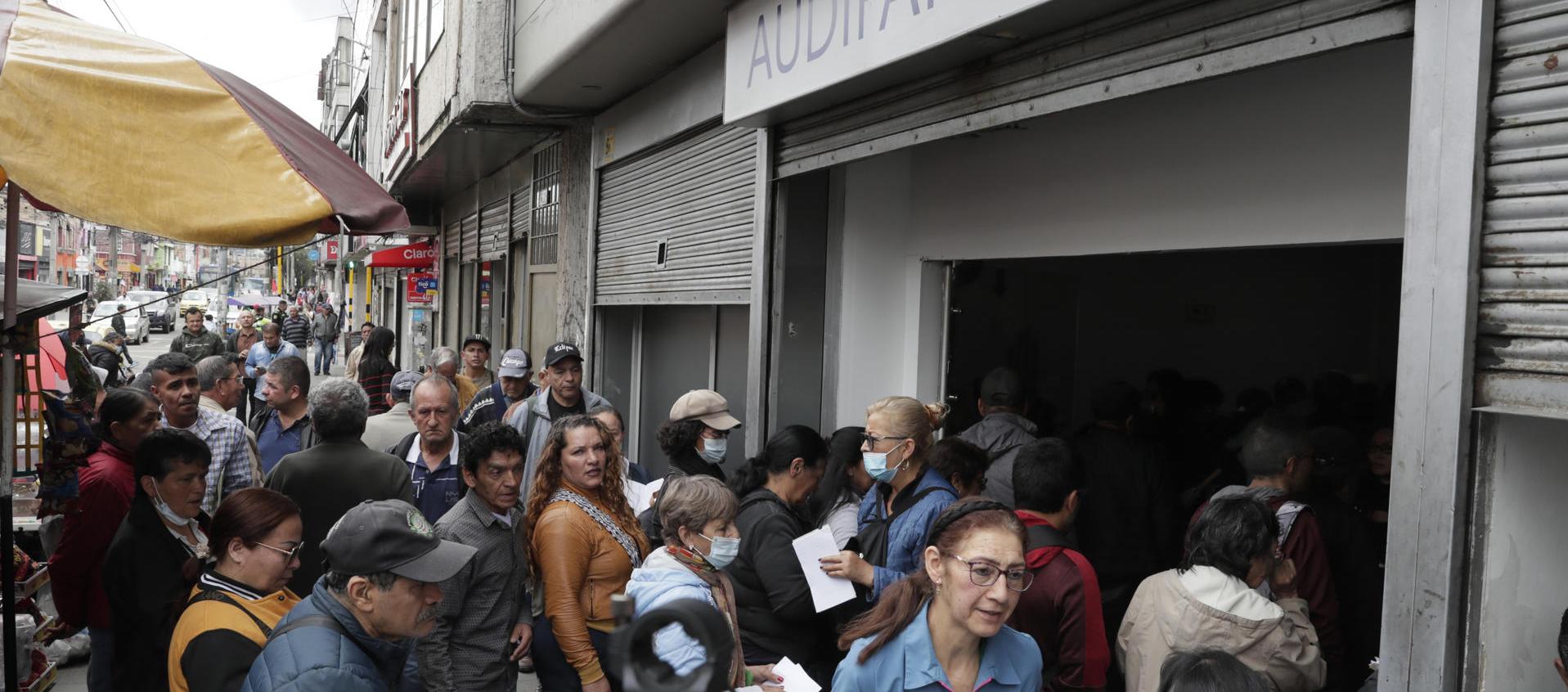 Largas filas para reclamar medicamentos en una droguería de Audifarma. 