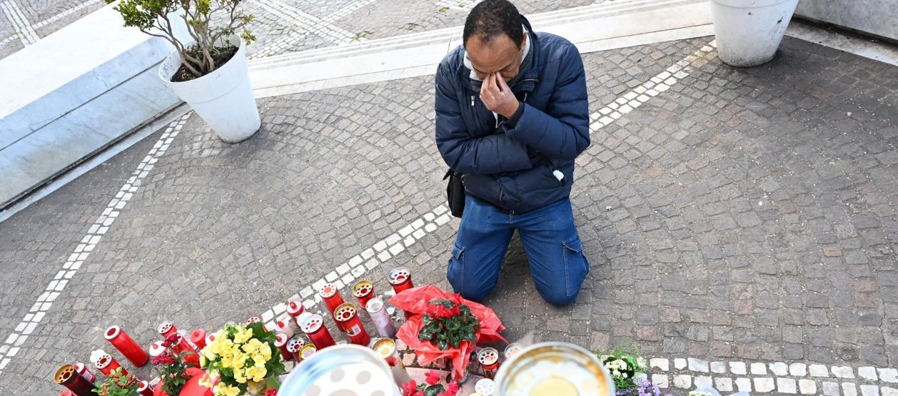 Un hombre reza junto a la estatua de Juan Pablo II en el hospital Gemelli, en Roma.