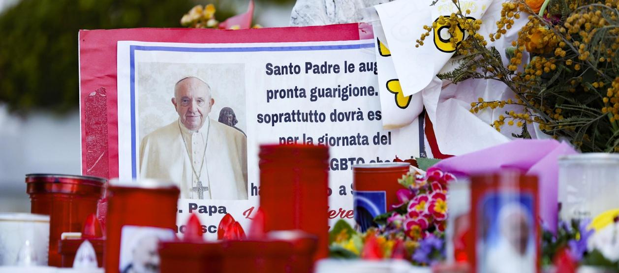 Los fieles dejan velas y tarjetas a los pies de la estatua de Juan Pablo II en la entrada del Hospital Gemelli.