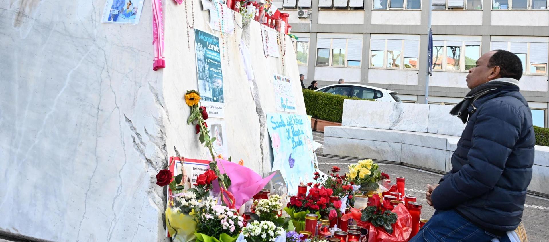 Un hombre reza delante del Policlínico Gemelli de Roma.