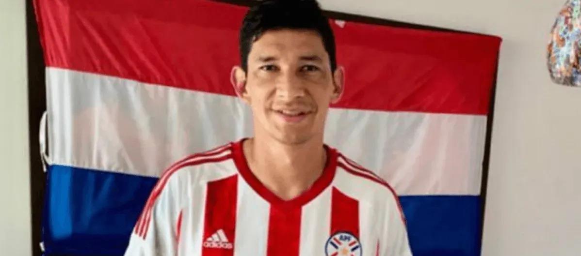 Roberto Ovelar con la camiseta y bandera de la selección paraguaya.