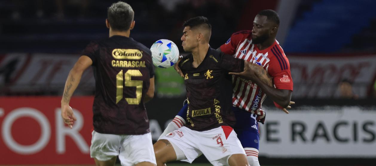 José Cuenú disputa la pelota con el delantero peruano Luis Ramos. 