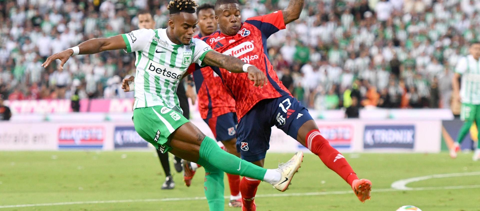 Fáber Gil, de Nacional, remata ante la marca de Francisco Chaverra. 