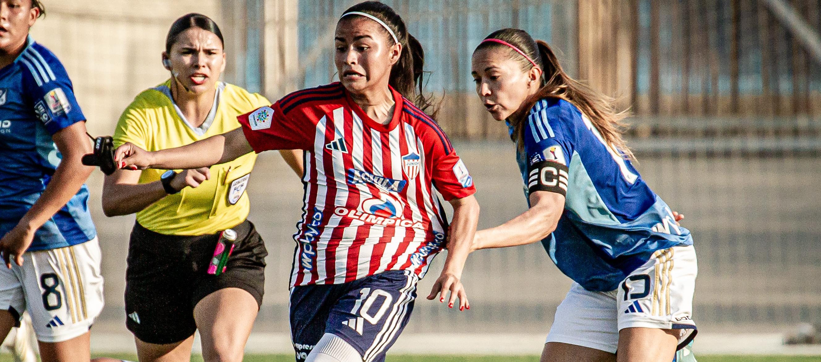 Wesly Rodríguez avanza con la marca de una jugadora de Millonarios.