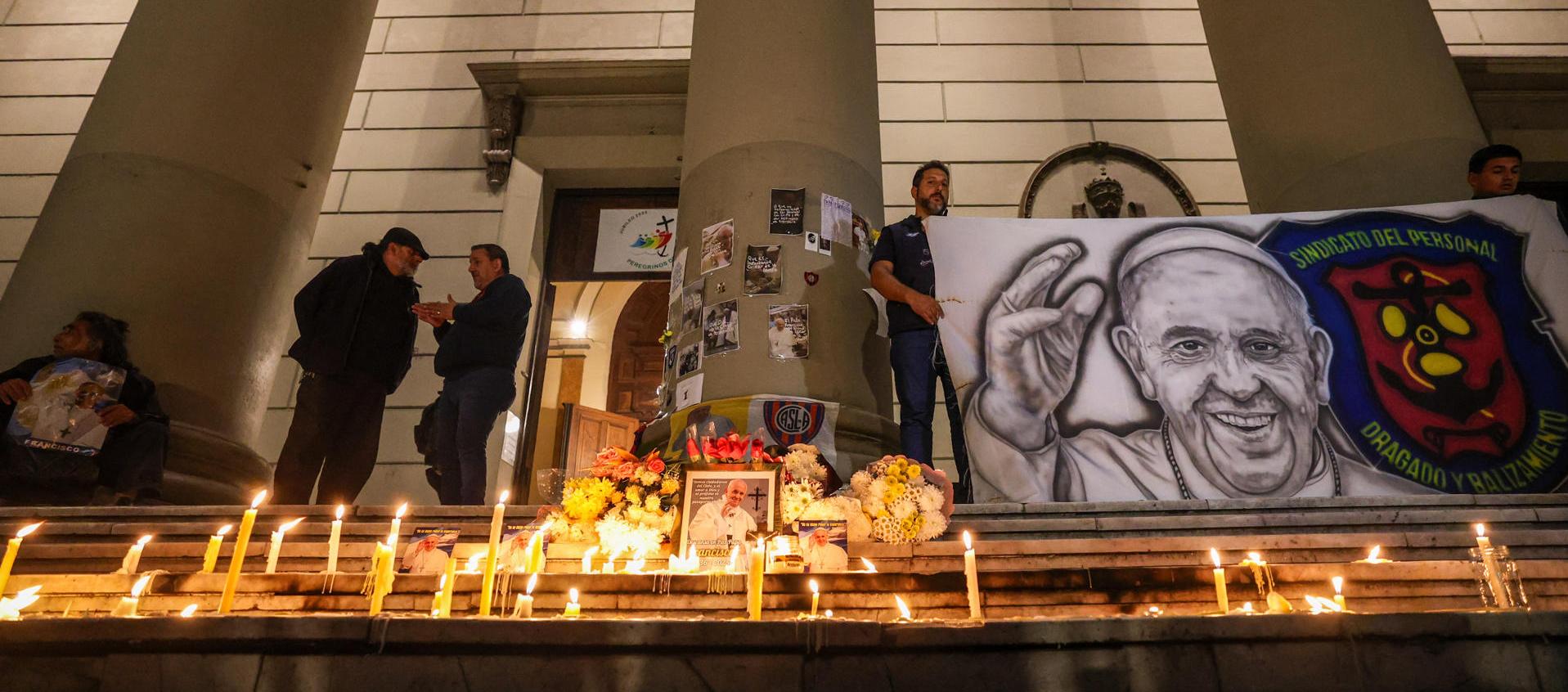 Personas encienden velas durante un homenaje al papa Francisco en la Catedral de Buenos Aires. 