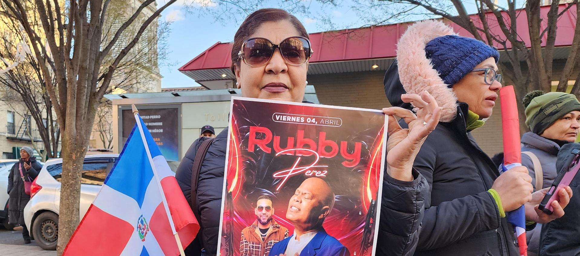 Mujer sosteniendo un cartel del cantante Rubby Pérez.